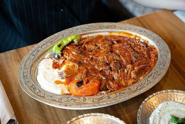 Iskender Kebab with doner meat, tomato sauce, and yogurt, a top pick for the best Turkish food to try.